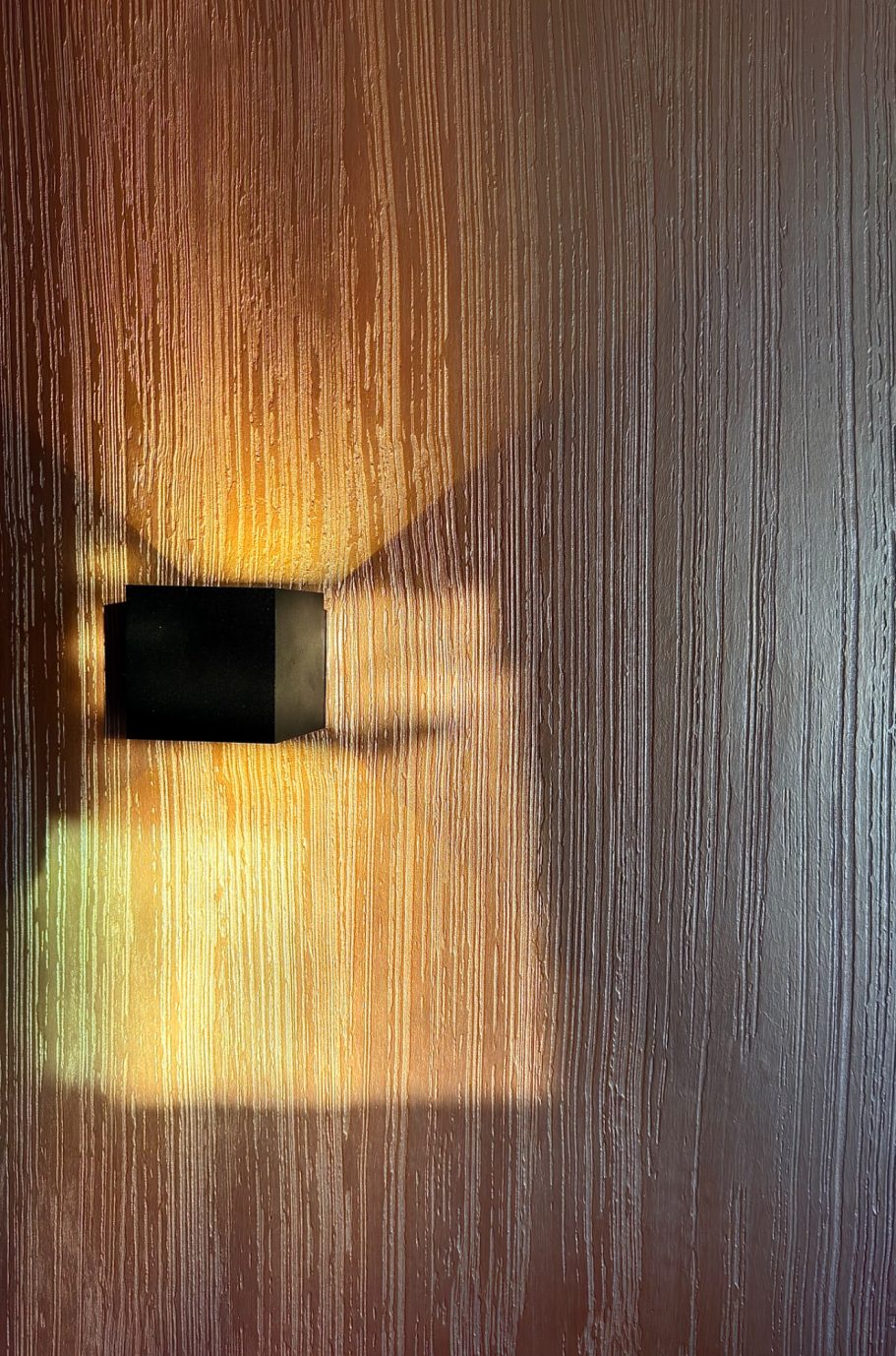 Ein Lichtstrahl fällt auf eine Holzoberfläche und erzeugt Farben und Schatten.