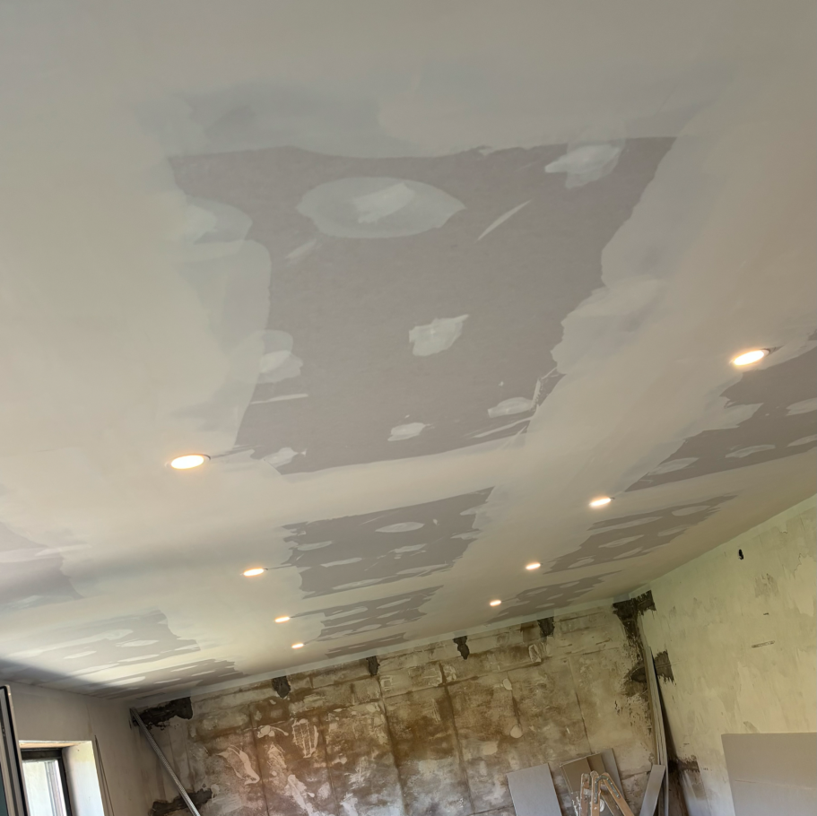 Der Raum mit einer unvollständigen Decke und mehreren eingebauten Lichtern.